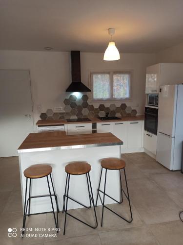 eine Küche mit einer Theke und 2 Hockern in der Unterkunft Un coin de campagne in Le Puy-Sainte-Réparade