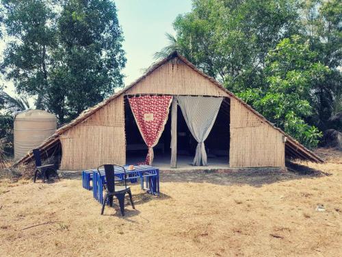 a hut with a table in front of it at Salt Field Glamping in Kampot