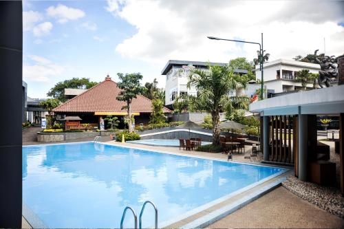 a large blue swimming pool next to a building at Griya Persada Convention Hotel & Resort Bandungan in Bandungan