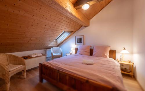 ein Schlafzimmer mit einem großen Bett im Dachgeschoss in der Unterkunft Ferienwohnung „Rose“ in Wiesenfelden
