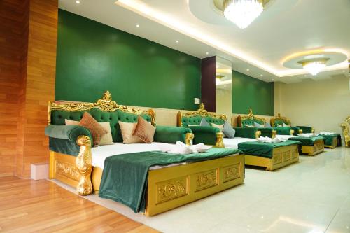德奧加爾的住宿－MAHARAJA DORMITORY，一间设有四张床和绿色墙壁的客房