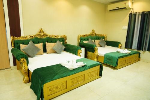 duas camas num quarto com verde e dourado em MAHARAJA DORMITORY em Deoghar