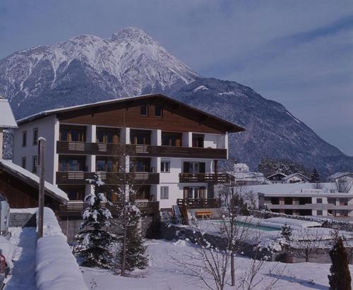 un gran edificio con una montaña en el fondo en Appartements Dobler - s'Zischgn, en Arzl im Pitztal