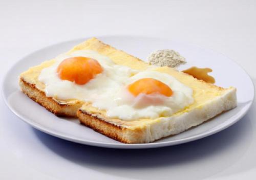 a plate with a piece of bread with eggs on it at Hotel Five Season Lahore in Lahore