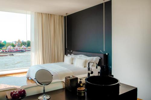 a hotel room with a bed and a window at Sala Rattanakosin Bangkok in Bangkok