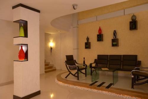 ein Wohnzimmer mit einem Sofa, Stühlen und einem Tisch in der Unterkunft Aec Travels and Leisure Solution Pvt Ltd in Alappuzha