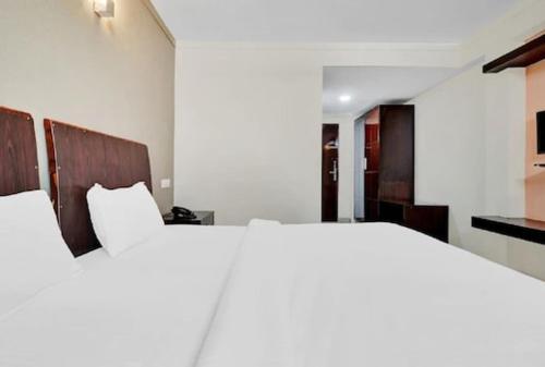 ein Schlafzimmer mit einem großen weißen Bett und ein Zimmer in der Unterkunft Aec Travels and Leisure Solution Pvt Ltd in Alappuzha