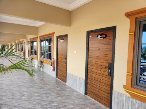 a row of wooden doors on a building at C-VISION GUESTHOUSE in Sefwi Bekwai