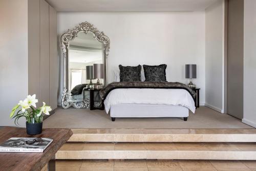 a bedroom with a large bed and a mirror at The Franklin Loft Apartments Johannesburg in Johannesburg