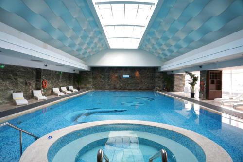 a large swimming pool in a building with a ceiling at InterContinental Dalian, an IHG Hotel in Dalian