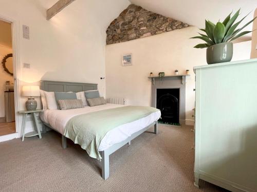 a bedroom with a bed and a fireplace at Cosy Cottage Central Marazion with Parking in Marazion
