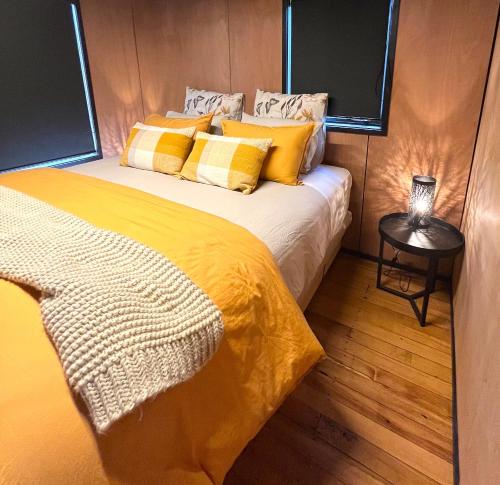 a bedroom with a bed with yellow sheets and a table at Mango Magic in Mangakino