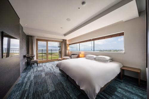 Habitación de hotel con cama grande y ventana grande. en Jeju Seongsan Golden View en Seogwipo
