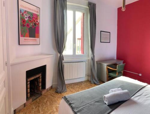 a red bedroom with a bed and a fireplace at Maison MAGNOLIA in Chasse-sur-Rhône