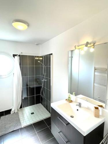 une salle de bain avec un lavabo et une douche dans l'établissement Charmante Maison à la mer proche plage, à Saint-Hilaire-de-Riez