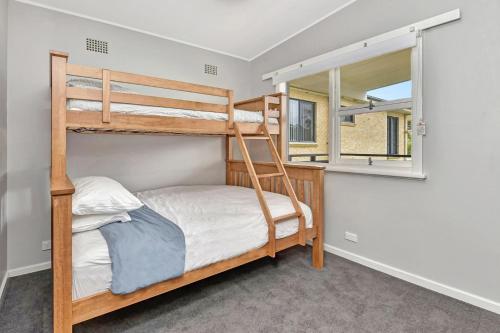 1 dormitorio con 2 literas y ventana en Waterfront Bliss at Balmoral Lake Macquarie, en Balmoral