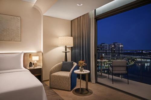 a bedroom with a bed and a window with a view at Palace Dubai Creek Harbour in Dubai