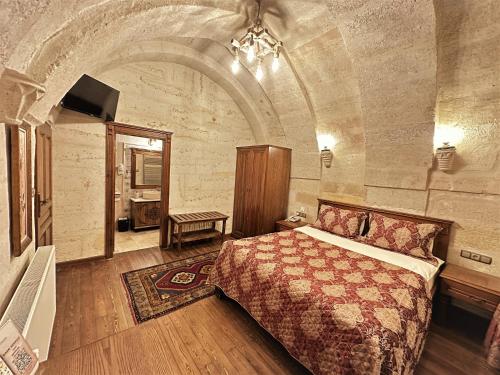 a bedroom with a bed in a stone room at Stone House Cave Hotel in Goreme