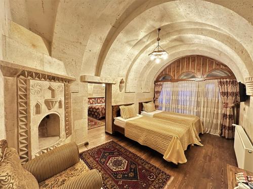 a bedroom with a bed and a fireplace at Stone House Cave Hotel in Goreme