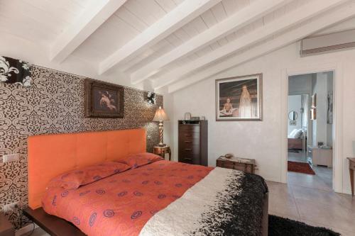 une chambre avec un lit avec un couvre-lit orange dans l'établissement MATTEOTTi Apartments, à Desenzano del Garda