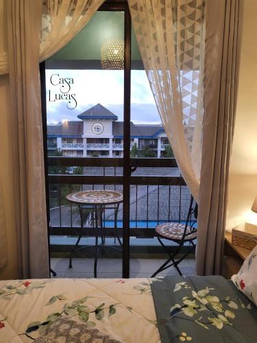 a bedroom with a window with a view of a balcony at Casa Lucas a Serene Stay in Pine Suites Tagaytay in Tagaytay