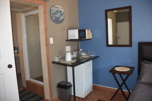 a small kitchen with a microwave on a blue wall at CasaC Guesthouse in Sasolburg