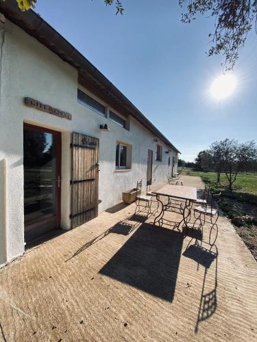 un bâtiment avec une table et des bancs devant lui dans l'établissement Centre médiation équine La Daouste, à Jouques