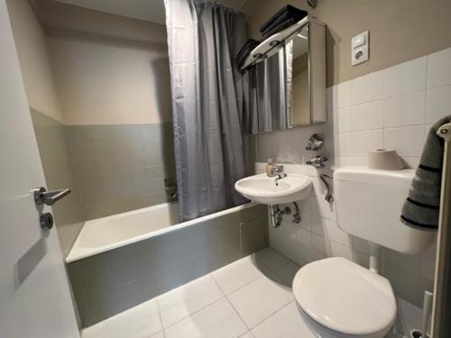 La salle de bains est pourvue de toilettes, d'un lavabo et d'une baignoire. dans l'établissement Savanna Ferienwohnung, à Rodenbach