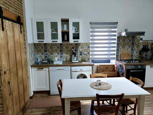 una cucina con tavolo bianco, tavolo e sedie di L'Oustal a Montech