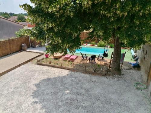 einen Hinterhof mit einem Pool und einem Baum in der Unterkunft L'Oustal in Montech