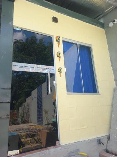 a front door of a house with blue curtains at Hostel Sossego do Garças in Barra do Garças