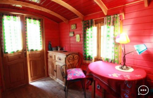a red kitchen with a red table and chairs at Centre médiation équine La Daouste in Jouques