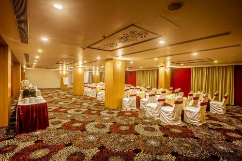 a banquet hall with tables and chairs in a room at Vesta Grand Central Udaipur in Udaipur