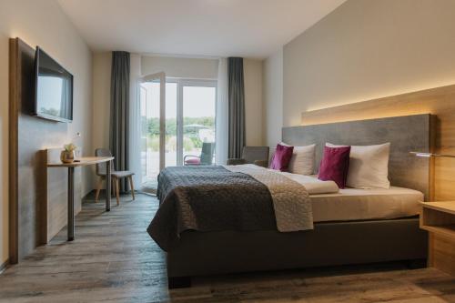 Habitación de hotel con cama con almohadas rosas en Pension Casamia, en Spremberg