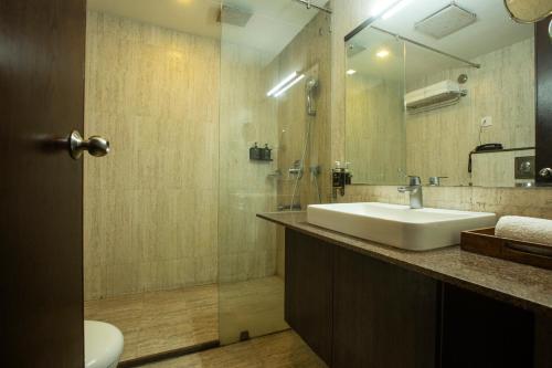 a bathroom with a sink and a mirror and a toilet at Vesta Grand Central Udaipur in Udaipur