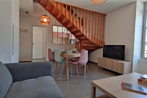 ein Wohnzimmer mit einem Sofa und einem Tisch mit Stühlen in der Unterkunft Superbe duplex « le Grévy » in Dole