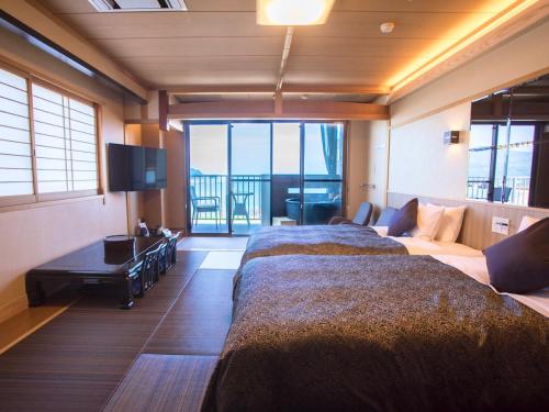 京丹後市にあるリブマックスリゾート 京丹後シーフロントのベッドルーム(大型ベッド1台、ソファ付)