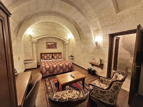 a bedroom with a bed and a table and chairs at Stone House Cave Hotel in Goreme