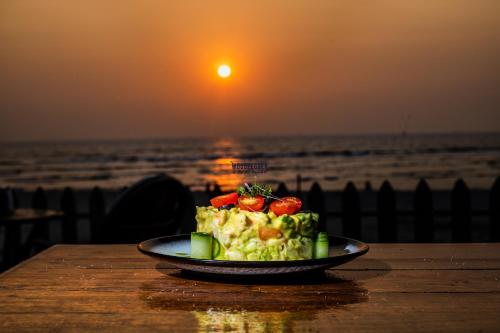 a plate of food on a table at the beach at Woodpegger By The Beach, Mandrem in Mandrem