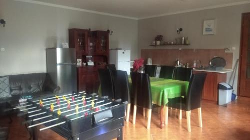 ein Wohnzimmer mit einem grünen Tisch und Stühlen in der Unterkunft Tímea Vendégház in Demjén