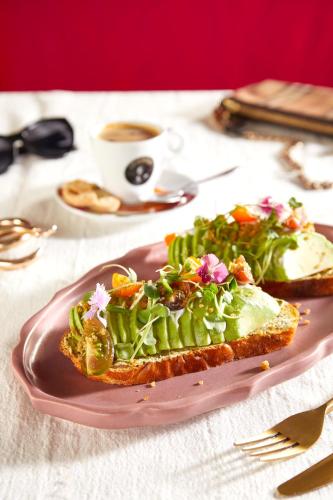 a pink plate with a sandwich and salad on a table at JW Marriott Mumbai Juhu in Mumbai