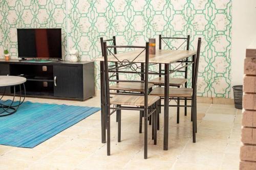 Cette chambre comprend une table et des chaises. dans l'établissement Laha Apartment 3, à Maun