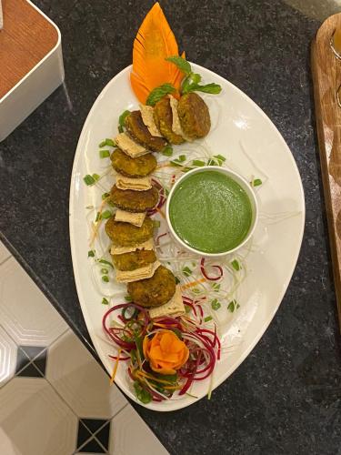 a plate of food with meatballs and a bowl of sauce at The Shanti A Boutique Hotel in Jodhpur