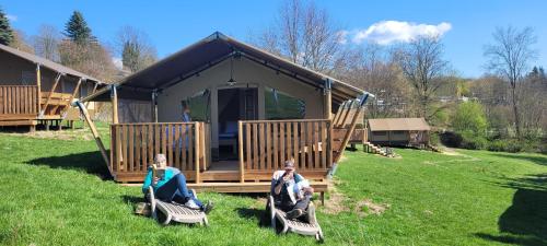 two people sitting on chairs in front of a house at KNAUS Campingpark Hennesee in Meschede