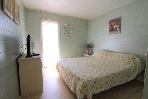 une chambre avec un lit et une télévision dans l'établissement GASMIM41 - Golfe de St-Tropez - Chalet 3 chambres climatisé dans domaine privé, à Gassin