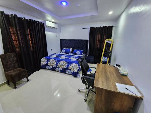 a bedroom with a desk and a bed in a room at Serene Oasis in Ikorodu