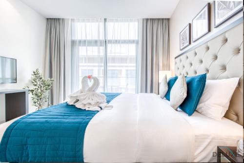 a bedroom with a large bed with a swan on it at Cozy Studio in Damac Celestia A Dubai South by Deluxe Holiday Homes in Dubai