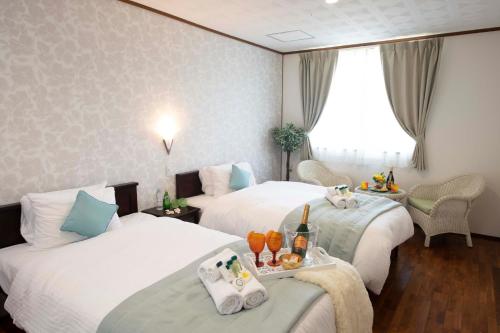 a hotel room with two beds and a window at Miyakojima White House Annex in Miyako-jima
