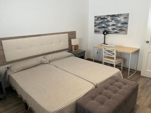 um quarto com uma cama e uma secretária com uma cadeira em Fuerteventura Family Luxury em Morro del Jable