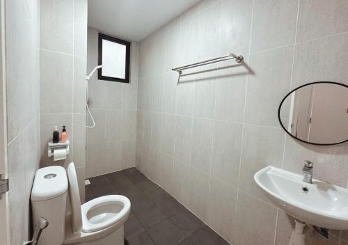 a bathroom with a toilet and a sink and a mirror at Tranquil Suite, MKH Boulevard 2 in Kajang